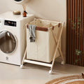 Panier à linge pliable crème dans une buanderie