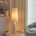 Lampadaire conique en tissu crème dans un salon