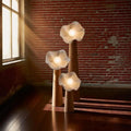 Trio de lampadaires fleur en résine et bois dans un salon