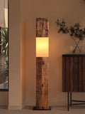 Lampadaire poutre en bois brut allumé dans un salon