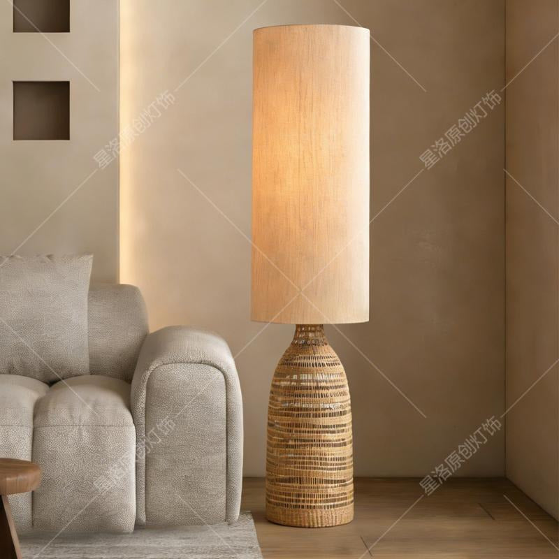 Lampadaire rotin tressé et abat-jour lin près d'un canapé