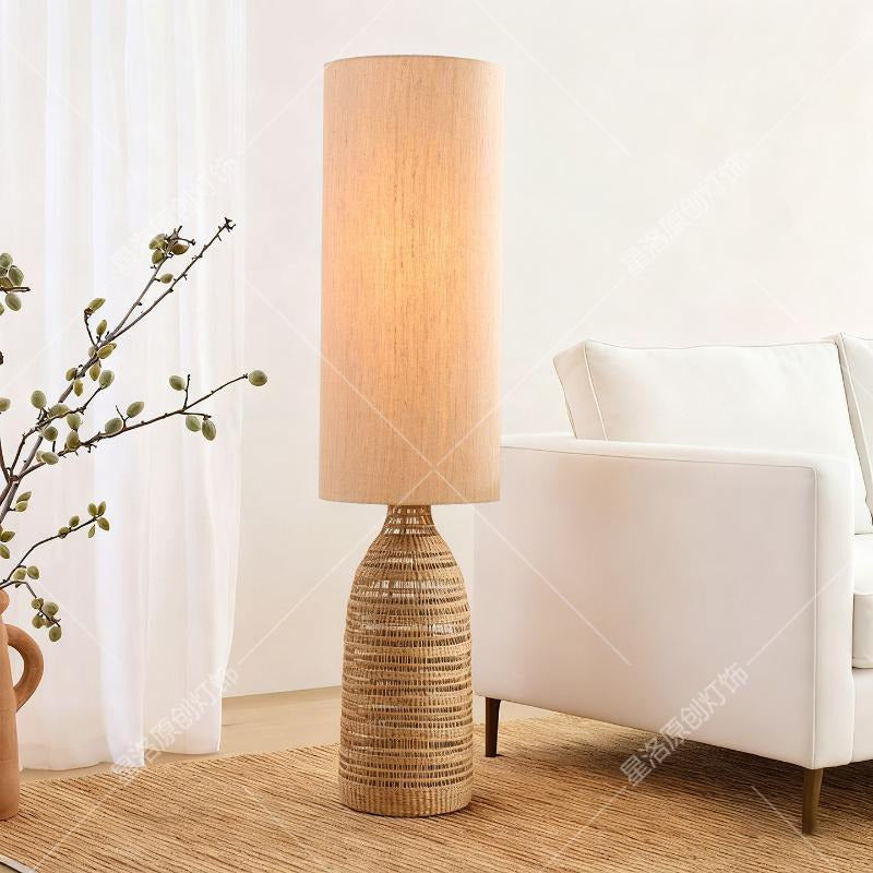 Lampadaire rotin tressé devant un voilage