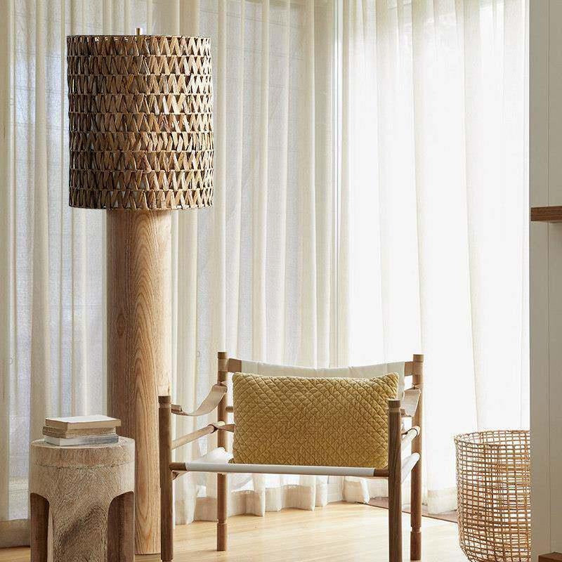 Lampadaire tressé devant un voilage