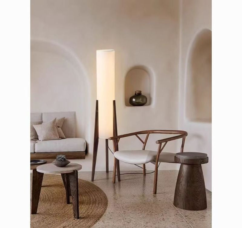 Lampadaire tripode bois près d'un fauteuil
