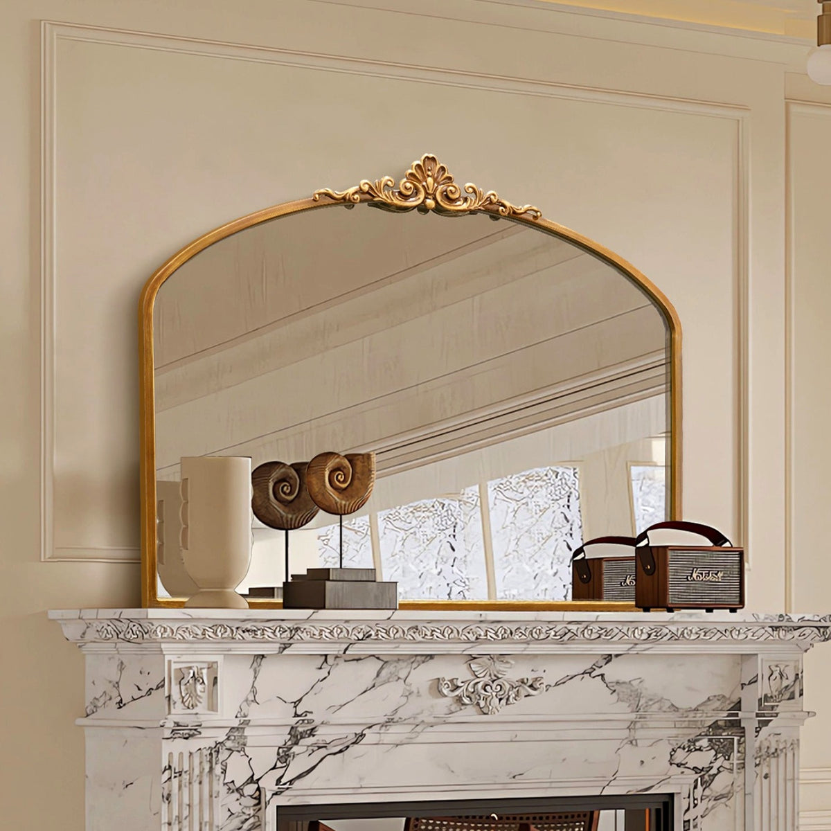 Miroir doré à fronton sculpté sur un manteau de cheminée