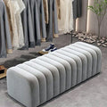 Banc bout de lit en velours cannelé gris perle dans un dressing