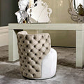 Fauteuil de coiffeuse pivotant capitonné en velours taupe devant une coiffeuse laquée