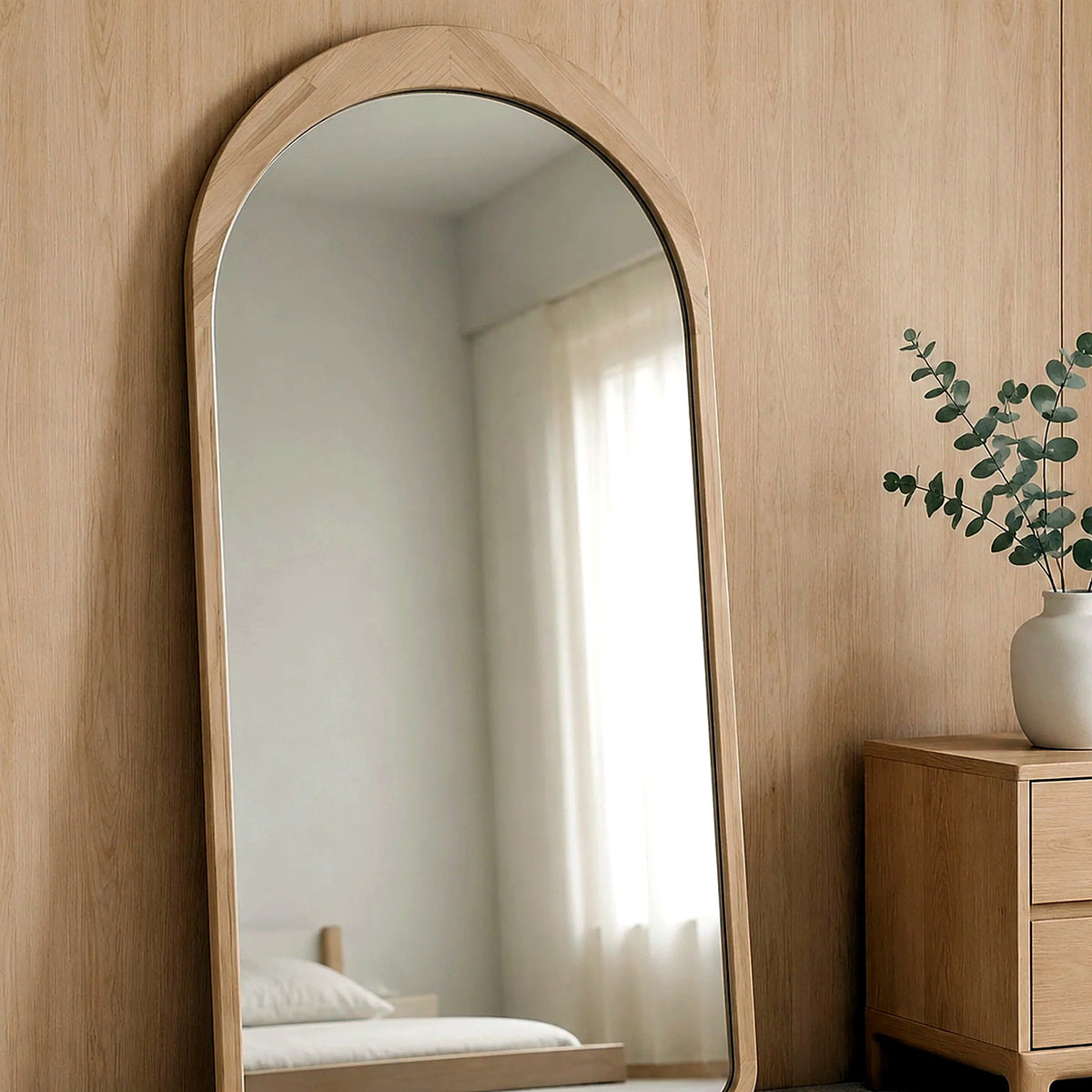 Miroir en arche bois clair contre un mur en bois