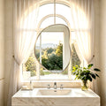 Miroir forme galet en inox dans une salle de bain lumineuse